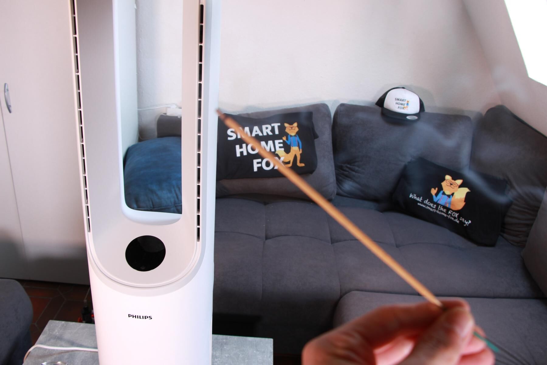 Палочка благовоний тлеет рядом с очистителем воздуха Philips Air Performer 7000 и башенным вентилятором, участвующим в тестировании.